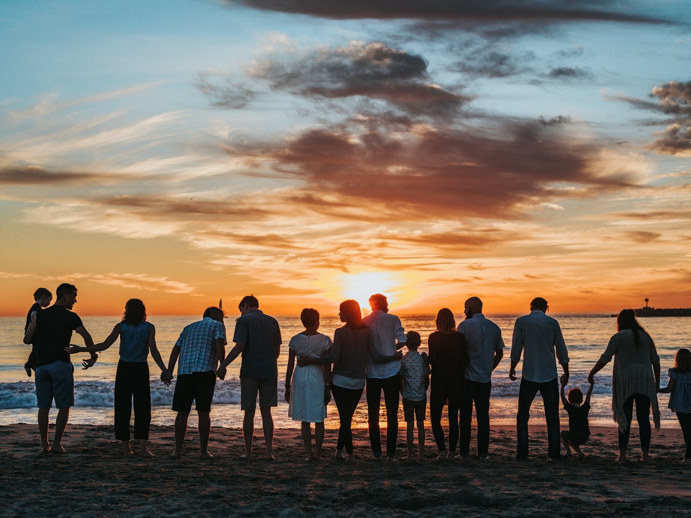 A multigenerational family together by the sea at sunset